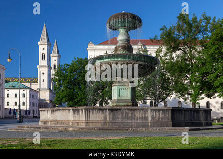 Puits en face de l'université Ludwig Maximilian avec Ludwigskirche (Église Saint-louis) dans Ludwigstrasse, Munich, Maxvorstadt, Haute-Bavière, Bavière, Allemagne, Banque D'Images