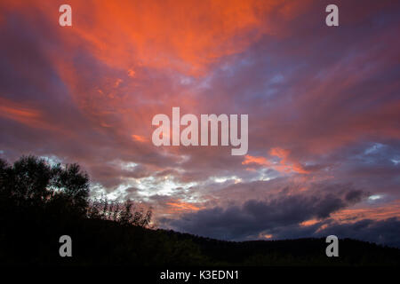 Le coucher du soleil et les nuages sur un ciel sombre sur les montagnes valley Banque D'Images