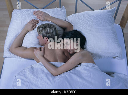 Jeune couple se trouve endormi dans le lit Banque D'Images