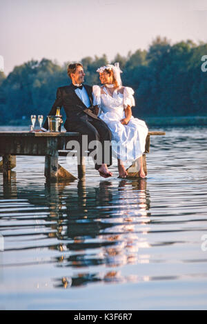 Wedding couple est assis sur un pont Banque D'Images