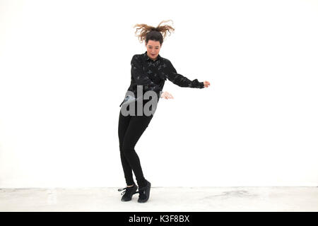 Jeune femme adulte dansant sur fond blanc Banque D'Images