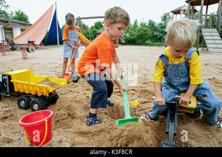 Trois enfants jouent au sable Banque D'Images