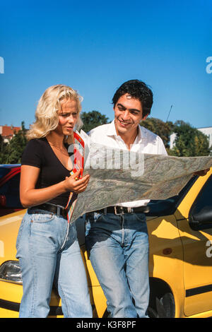 Jeune couple studies à l'avant du véhicule une carte routière Banque D'Images