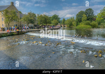 Image HDR de gens assis sur la rive par le barrage sur la rivière Wye à Backwell dans le Derbyshire UK Banque D'Images