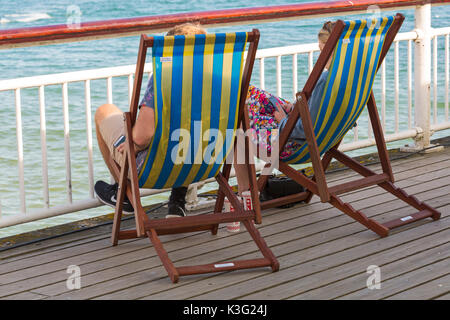 Bournemouth, Dorset, Royaume-Uni. 2 septembre 2017. Météo au Royaume-Uni : beau jour chaud et ensoleillé à la plage de Bournemouth. Couple se reposant dans des chaises longues sur la jetée de Bournemouth - vue arrière, vue arrière. Crédit: Carolyn Jenkins/Alay Live News Banque D'Images