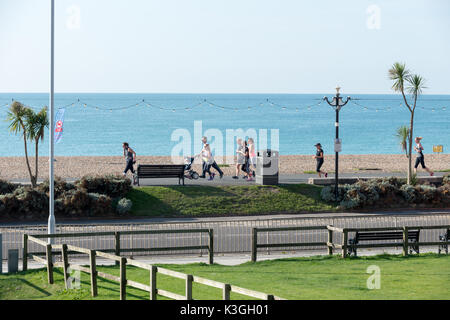 Un groupe de personnes courant le long de la promenade à Worthing, West Sussex, Angleterre. Banque D'Images