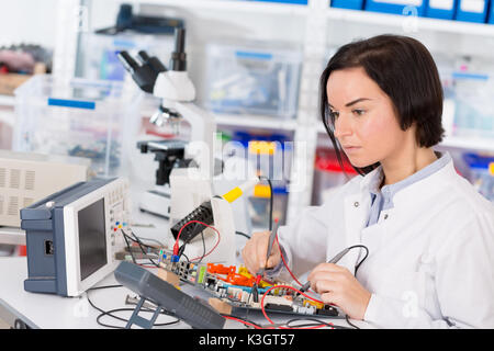 Assistant de laboratoire femelle module PCB Réparation pour CNC robotique. La mesure des paramètres du système électronique dans le laboratoire Banque D'Images