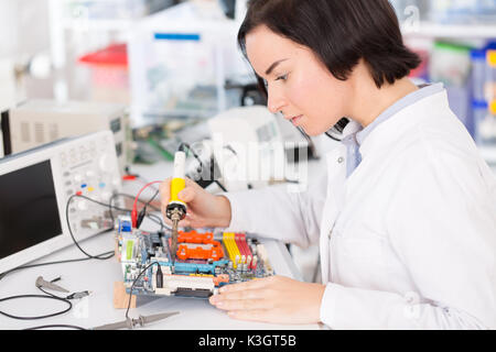 Assistant de laboratoire femelle module PCB Réparation pour CNC robotique. La mesure des paramètres du système électronique dans le laboratoire Banque D'Images