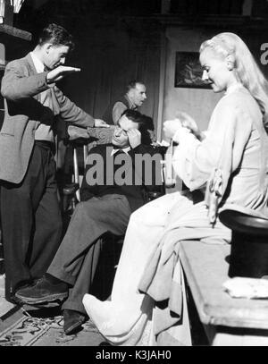 Le réalisateur David Lean [assis] confère à la photographie Guy vert sur l'ensemble de Madeleine [BR 1950] bien que la femme du directeur et l'actrice ANN TODD tricote en attendant sa prochaine scène Banque D'Images