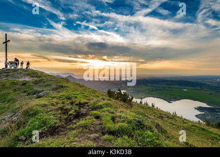 En vertu de l'randonneur sommet cross du Jochberg, sur le Kochelsee. Dans l'arrière-plan de couleur d'un coucher du soleil. Banque D'Images