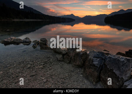 Pierres sur la rive de la Spain pendant le coucher du soleil et de la tempête sur les montagnes en arrière-plan Banque D'Images