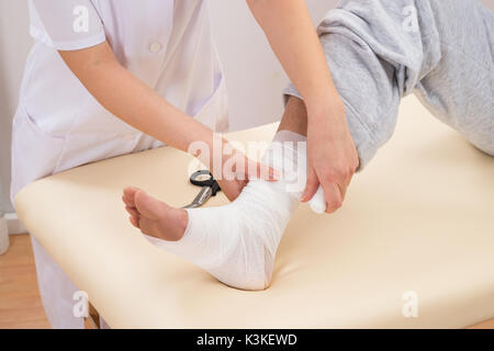 Close-up of a Woman Lier Bandage sur pied du patient Banque D'Images