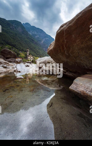 Les roches sur le lit de la rivière Verzasca et l'église de Lavertezzo, Valle Verzasca, Tessin, Suisse. Banque D'Images