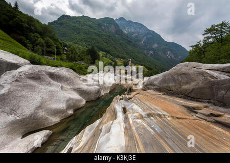 Les roches sur le lit de la rivière Verzasca et l'église de Lavertezzo, Valle Verzasca, Tessin, Suisse. Banque D'Images