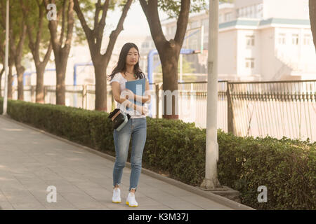 Fille sac de promenades dans le parc du campus Banque D'Images