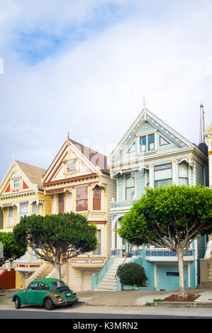 Un livre vert Volkswagen garée en face de la 'Painted Ladies' rangée de maisons victoriennes sur Steiner Street (à Alamo Square) à San Francisco. Banque D'Images