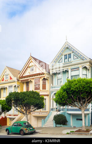 Un livre vert Volkswagen garée en face de la 'Painted Ladies' rangée de maisons victoriennes sur Steiner Street (à Alamo Square) à San Francisco. Banque D'Images