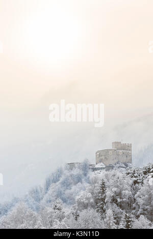 Un hiver suggestive vue sur le château de Saint Michel en Bruneck avec le premier soleil sortir la brume, la province de Bolzano, le Tyrol du Sud, Trentin-Haut-Adige, Italie, Europe Banque D'Images