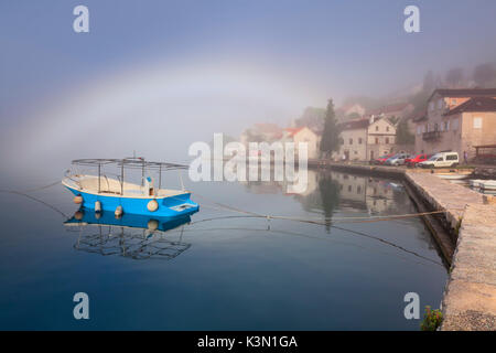 Perast est une vieille ville, dans la baie de Kotor au Monténégro. Dans la photo un matin brumeux sur la baie avec un peu d'arc en ciel. Banque D'Images