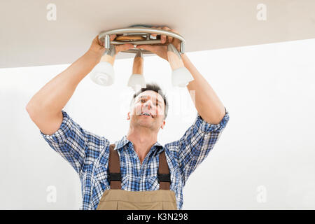 Portrait Of A Male Electrician Fixing Lumière au plafond Banque D'Images