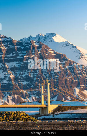 Jokulsarlon, est de l'Islande, Islande. Le pont sur la lagune du glacier et les montagnes en toile de fond. Banque D'Images