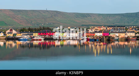 Portmagee (Un Caladh), comté de Kerry, Munster, Irlande, province de l'Europe. Vue panoramique de la couleur des maisons qui se reflètent dans les eaux du port au crépuscule. Banque D'Images