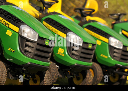 Une rangée de monter sur les tondeuses à gazon pour être vendus dans une jardinage agricole met en œuvre pour un grand jardin tracteurs de tonte des pelouses et de style Banque D'Images