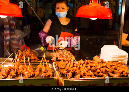 NANNING, CHINE - 9 juin 2017 : chef chinois préparation barbecue sur la rue de Zhongshan, un marché d'alimentation à Nanning. Cette nourriture est la rue bigges Banque D'Images