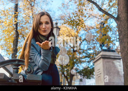 Woman in love blowing kiss in autumn park Banque D'Images