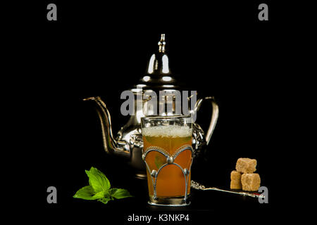 Vrai thé à la menthe marocain dans la coupe originale et théière sur le fond noir Banque D'Images