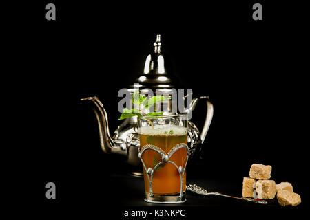 Vrai thé à la menthe marocain dans la coupe originale et théière sur le fond noir Banque D'Images
