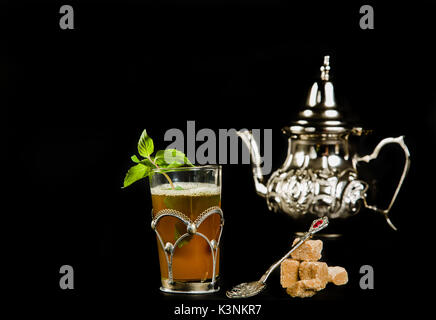 Vrai thé à la menthe marocain dans la coupe originale et théière sur le fond noir Banque D'Images