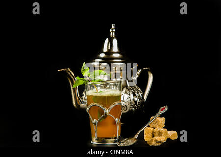 Vrai thé à la menthe marocain dans la coupe originale et théière sur le fond noir Banque D'Images