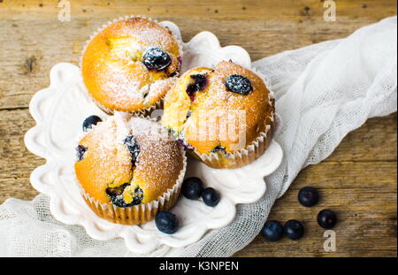 Des muffins aux bleuets avec des baies sur une table en bois Banque D'Images