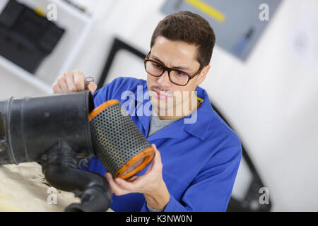 Mécanicien professionnel filtre de nettoyage dans son atelier Banque D'Images
