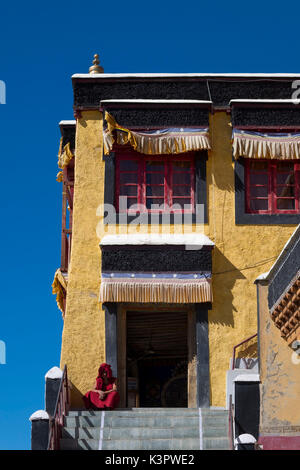 Le monastère de Thiksey, vallée de l'Indus, Ladakh, Inde, Asie. Le moine bouddhiste en face de temple central entrée. Banque D'Images