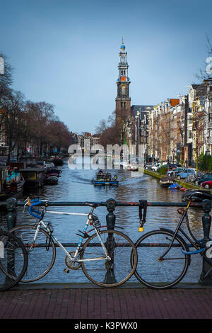 Amsterdam, Pays-Bas, Europe. Vélos garés sur le pont avec Westkerk en arrière-plan. Banque D'Images