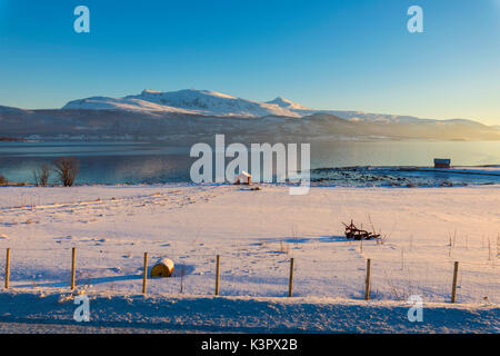 Cabane en bois dans le paysage de neige en face de la mer froide sur la route menant de Gibostad à Finnsnes Senja Tromsø Norvège Europe Banque D'Images