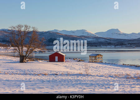 Cabane en bois dans le paysage de neige en face de la mer froide sur la route menant de Gibostad à Finnsnes Senja Tromsø Norvège Europe Banque D'Images