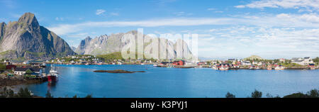 Panorama de la mer bleue entourant le village de pêcheurs et pics rocheux Reine Norvège Iles Lofoten Moskenes Europe Banque D'Images