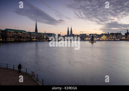 Photographe admire le lac Inner Alster avec l'arbre de Noël suspendue dans son eau au crépuscule Hambourg Allemagne Europe Banque D'Images