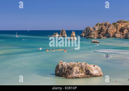 Canots dans l'eau turquoise de l'océan Atlantique qui entourent la plage Praia Dona Ana Lagos Algarve Portugal Europe Banque D'Images