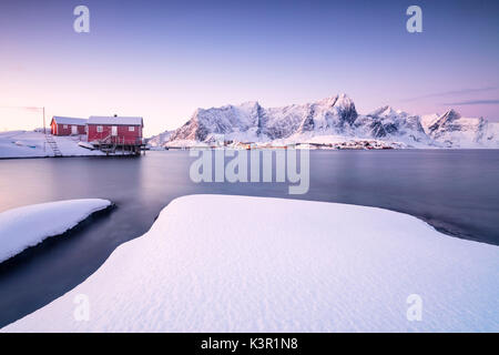 Les couleurs de l'aube les cadres de maisons de pêcheurs entouré par la mer gelée Sakrisøy Reine Nordland îles Lofoten Norvège Europe Banque D'Images