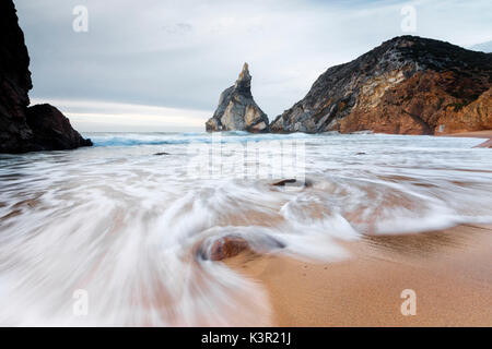 En mer, les vagues se brisant sur la plage de sable de Praia da Ursa entourée de falaises Cabo da Roca Colares Sintra Portugal Europe Banque D'Images