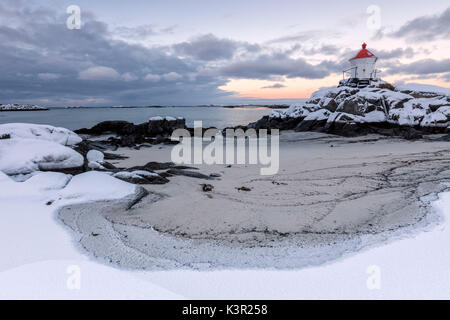 L'Arctique coloré coucher de soleil sur le phare entouré de neige et de glace l'Île Vestvagoy sable Eggum Lofoten, Norvège Europe Banque D'Images