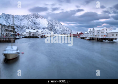 Le typique village de pêcheurs de Henningsvær entouré de montagnes enneigées et la mer froide du nord de l'Europe Norvège Iles Lofoten Banque D'Images