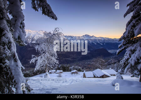 Lumières de l'aube sur la neige couverts abris et arbres Tagliate Di Sopra Gerola Valley Alpes Orobie Valtellina Lombardie Italie Europe Banque D'Images