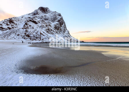 L'aube éclaire la neige partiellement couverts plage de Uttakleiv. Lofoten, Norvège Europe Banque D'Images