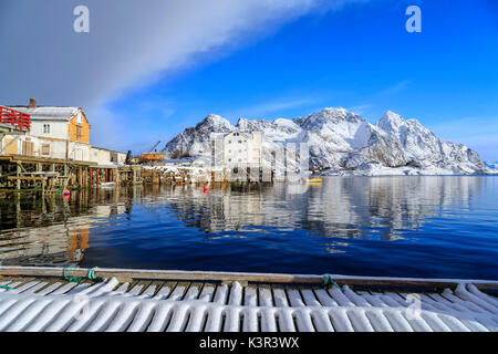 Le soleil éclaire les maisons surplombant le port de Henninsvaer. Iles Lofoten. La Norvège. L'Europe Banque D'Images