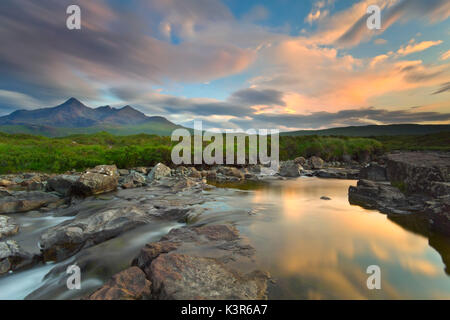 Île de Skye, en Écosse, en Europe. Le dernier coucher de soleil couleurs reflète dans l'eau. Dans l'arrière-plan les sommets de l'Black Cuillin. Banque D'Images